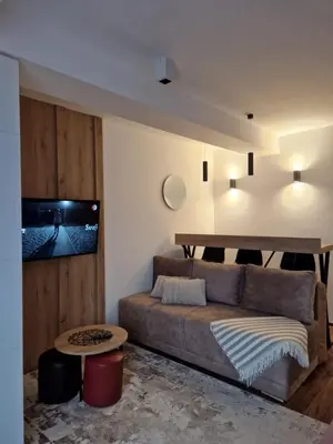 a living room with a couch and a table at SkyKop Apartmani in Kopaonik