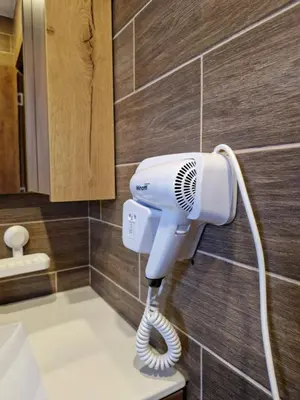 a blow dryer is attached to a wall in a bathroom at SkyKop Apartmani in Kopaonik