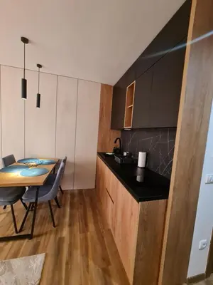 a kitchen with a table and a dining room at SkyKop Apartmani in Kopaonik