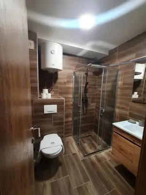 a bathroom with a toilet and a glass shower at SkyKop Apartmani in Kopaonik