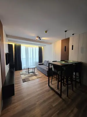 a living room with a table and a couch at SkyKop Apartmani in Kopaonik