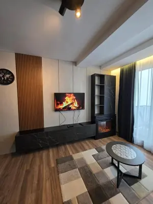a living room with a fireplace and a tv at SkyKop Apartmani in Kopaonik