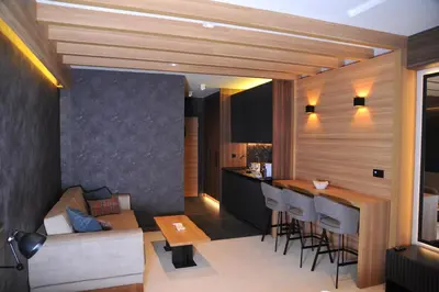 a kitchen and living room with a couch and a table at Family Apart Woodside in Kopaonik