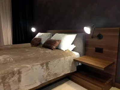 a bedroom with a bed with two pillows and a table at Family Apart Woodside in Kopaonik