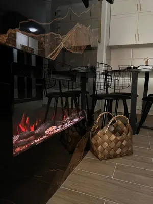 a fireplace in a living room with a table and chairs at MVP Apartment Kopaonik in Kopaonik