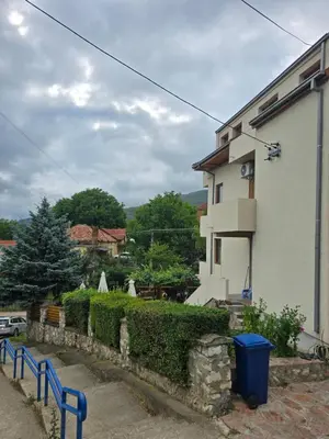 a white house with a blue fence next to it at APARTMANSKI SMEŠTAJ SOLARIS kod Aqua Parka SUPERIOR & FAMILY Apartments in Soko Banja