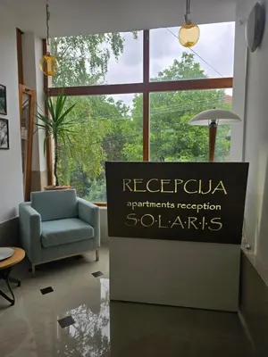 a sign in a room with a chair and a window at APARTMANSKI SMEŠTAJ SOLARIS kod Aqua Parka SUPERIOR & FAMILY Apartments in Soko Banja