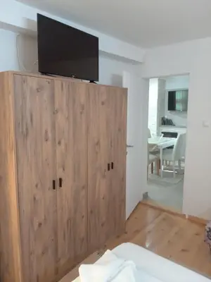 a living room with a tv on top of a wooden cabinet at APARTMANSKI SMEŠTAJ SOLARIS kod Aqua Parka SUPERIOR & FAMILY Apartments in Soko Banja