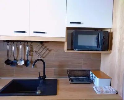 a kitchen with a sink and a tv and a counter at Milmari-Kopaonik in Kopaonik