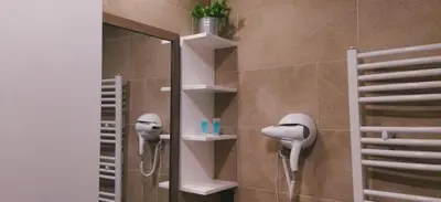 a shower with a hair dryer and a mirror in a bathroom at Milmari-Kopaonik in Kopaonik