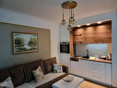 a living room with a couch and a kitchen at Rajski kutak - Centar in Kopaonik