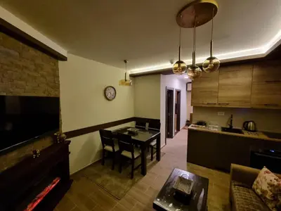 a kitchen and dining room with a table and a counter at Rajski kutak - Centar in Kopaonik
