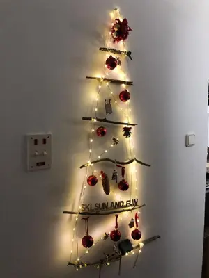 a christmas tree with lights on a wall at Ski sun and fun kopaonik apartmani in Brzeće