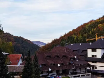 a group of buildings with mountains in the background at Ski sun and fun kopaonik apartmani in Brzeće