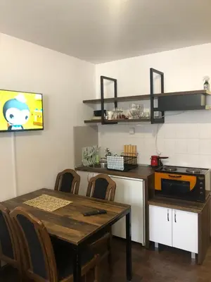 a kitchen with a table and chairs and a television at Ski sun and fun kopaonik apartmani in Brzeće