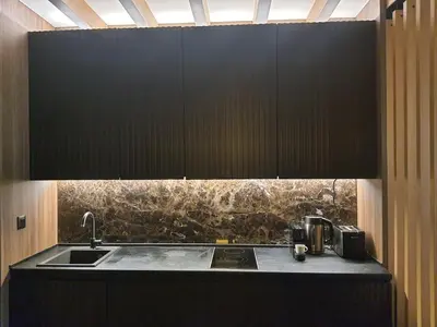 a kitchen with a sink and black cabinets at Woodside Kopaonik by Ister in Kopaonik