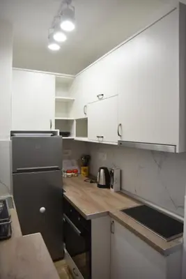 a kitchen with white cabinets and a black refrigerator at Stan Na Dan Central Park in Raška