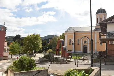 a yellow building with a clock tower on a street at Stan Na Dan Central Park in Raška
