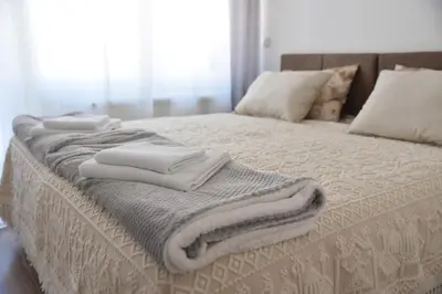 a bed with white blankets and pillows on it at Stan Na Dan Central Park in Raška