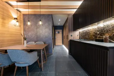 a kitchen with a wooden table and blue chairs at Woodside Apartment 218 in Kopaonik