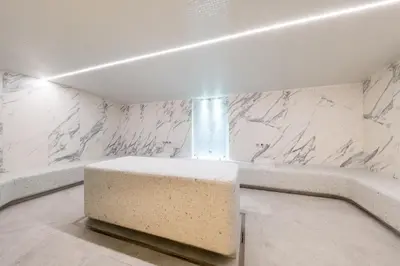 a bathroom with a bench and a marble wall at Woodside Residence 325 in Kopaonik