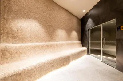 a bathroom with a walk in shower next to a brick wall at Woodside Residence 325 in Kopaonik