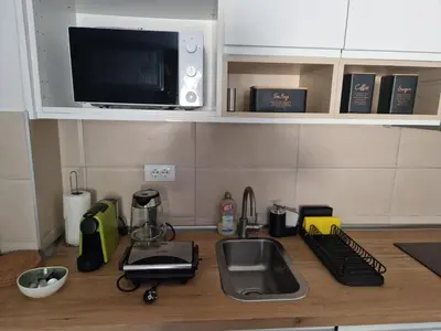 a kitchen counter with a sink and a microwave at BelinaKop - Kopaonik Centar in Kopaonik
