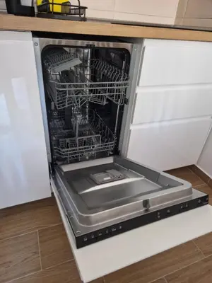 an open dishwasher with its door open in a kitchen at BelinaKop - Kopaonik Centar in Kopaonik
