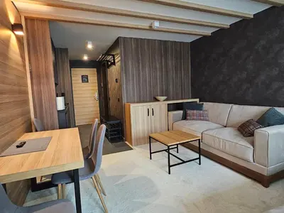 a living room with a couch and a table at Woodside apartments Kopaonik with garage in Kopaonik