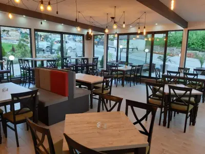 a restaurant with tables and chairs and windows at Mountain angel in Kopaonik