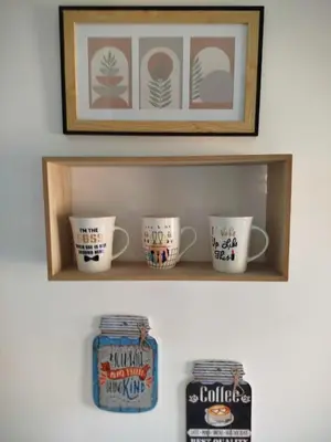 a shelf with three cups and a can of coffee at Fina Apartman in Leskovac