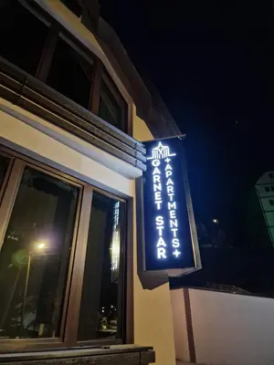 a sign on the side of a building at night at Garnet Star Apartments 1 in Kopaonik