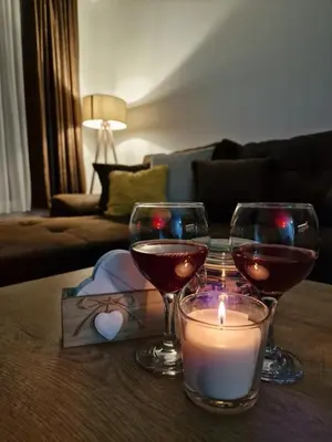 two glasses of wine and a candle on a table at Garnet Star Apartments 1 in Kopaonik