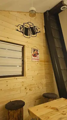 a log cabin with two stools and a window at Garnet Star Apartments 1 in Kopaonik