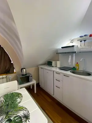 a kitchen with white cabinets and a sink at Freya SPA Apartments in Niš