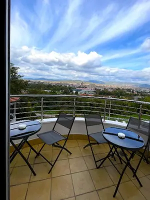 a balcony with three tables and chairs on a balcony at Freya SPA Apartments in Niš