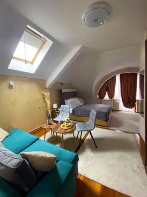 a bedroom with a bed and a couch and a table at Freya SPA Apartments in Niš