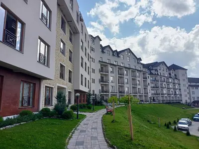 a large apartment building with a grassy hill next to it at Vorkapich Milmari Studio in Kopaonik
