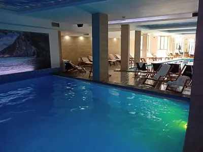a large swimming pool in a hotel with chairs at Vorkapich Milmari Studio in Kopaonik