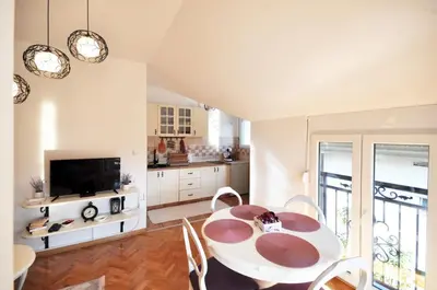 a kitchen and dining room with a table and chairs at Apartman Provansa in Vrnjačka Banja