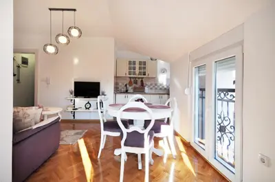 a kitchen and dining room with a table and chairs at Apartman Provansa in Vrnjačka Banja