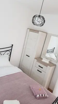 a bedroom with a bed with a dresser and a mirror at Apartman Provansa in Vrnjačka Banja