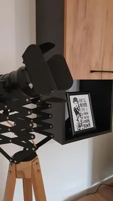 a black chair sitting next to a picture on a wall at Apartman Chaplin in Vrnjačka Banja