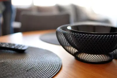 a black bowl on a wooden table with a remote control at Apartman Chaplin in Vrnjačka Banja