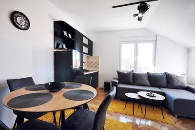 a living room with a table and a couch at Apartman Chaplin in Vrnjačka Banja