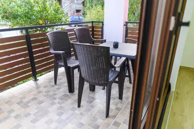 a patio with four chairs and a table on a balcony at Apartman Dina in Soko Banja