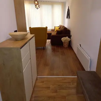 a kitchen and living room with a couch and wooden floors at Garnet Star Apartments, Kopaonik, apartman br 2 in Kopaonik