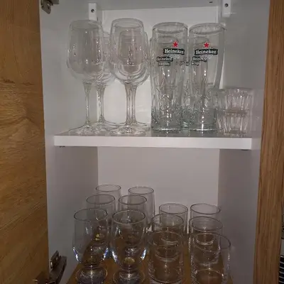 a bunch of empty wine glasses sitting on a shelf at Garnet Star Apartments, Kopaonik, apartman br 2 in Kopaonik