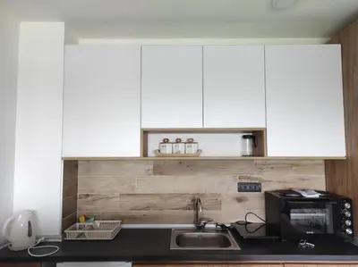 a kitchen with white cabinets and a sink and a microwave at Apartman N98 Milmari Kopaonik in Kopaonik