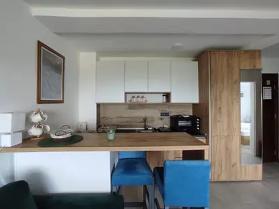 a kitchen with a wooden counter and blue chairs at Apartman N98 Milmari Kopaonik in Kopaonik